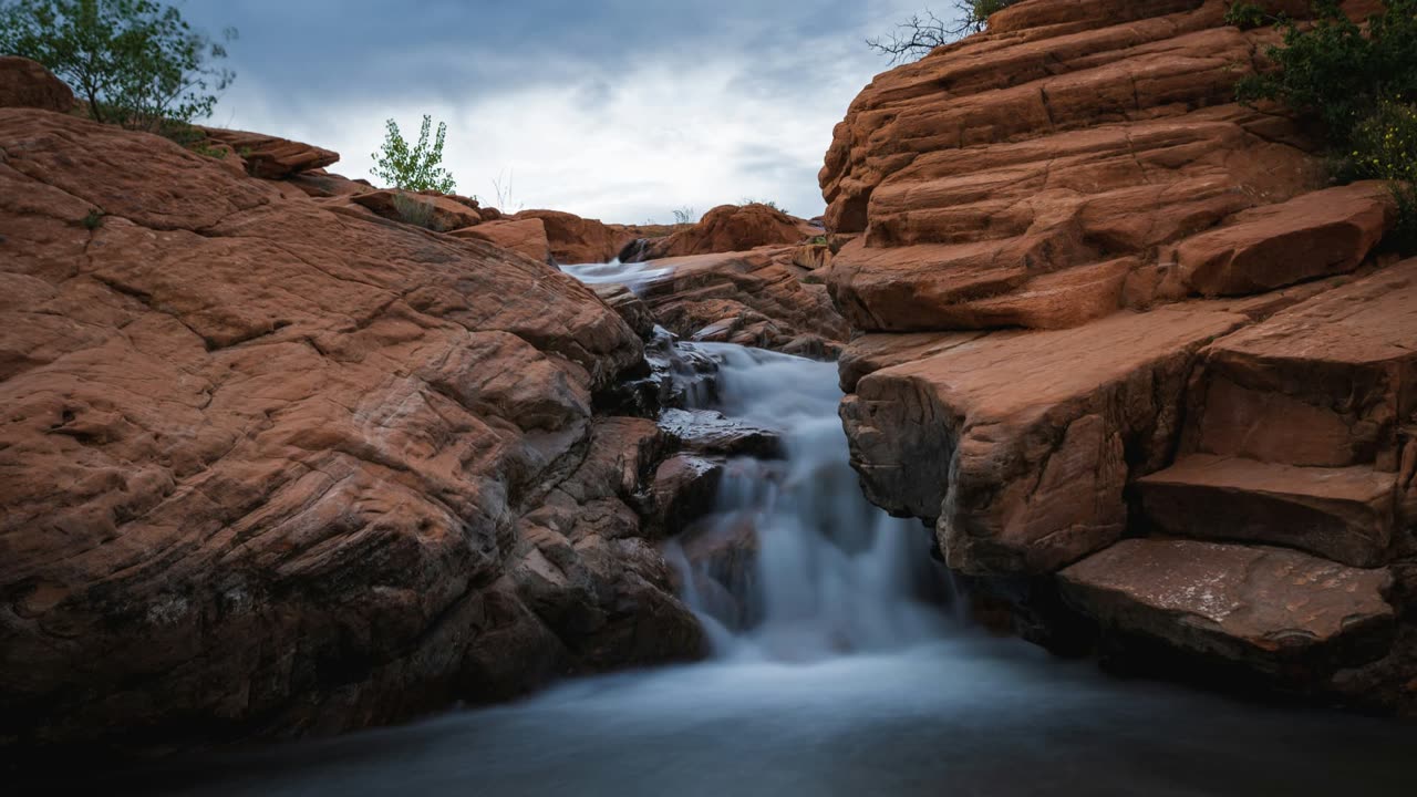 Waterfall flowing through red sandstone at Gunlock Falls near St. George, Utah — health insurance, ACA, and Obamacare coverage across Southern Utah