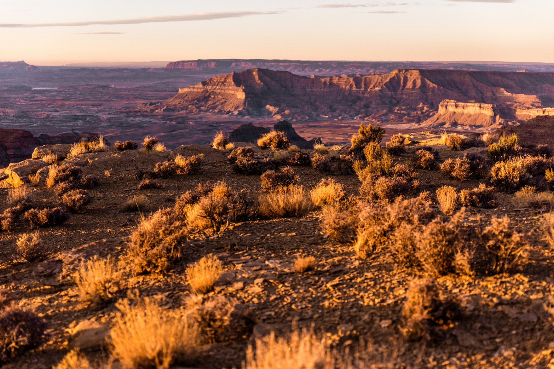 Vermilion Cliffs and Grand Staircase mesas glowing at sunset above the sagebrush flats south of Kanab, Utah — the wildland-urban interface, remote Kane County fire-response distance, and monsoon-wind exposure carriers rate into every 84741 homeowners insurance quote