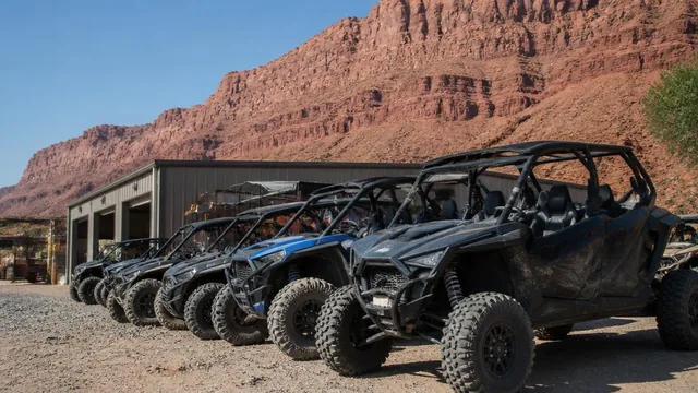 Off-road tour vehicles staged outside a shop beneath the red cliffs of Hurricane, Utah — local commercial insurance risk factors for Hurricane, Utah 84737 businesses