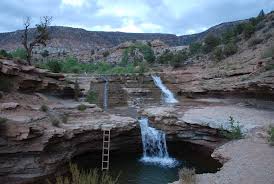 Lower plunge pool and red sandstone amphitheater at Toquerville Falls near Toquerville, Utah — the BLM road traffic and short-term-rental driver mix that shapes 84774 auto risk