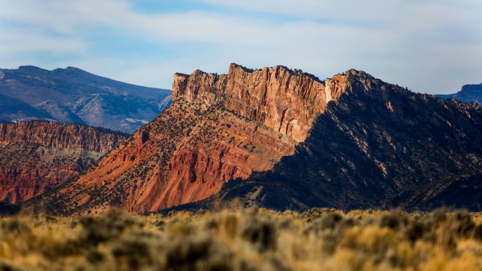 Sunlit red sandstone cliffs above sagebrush flats outside Kanab, Utah — ACA / Obamacare health insurance enrollment for Kane County households in ZIP 84741