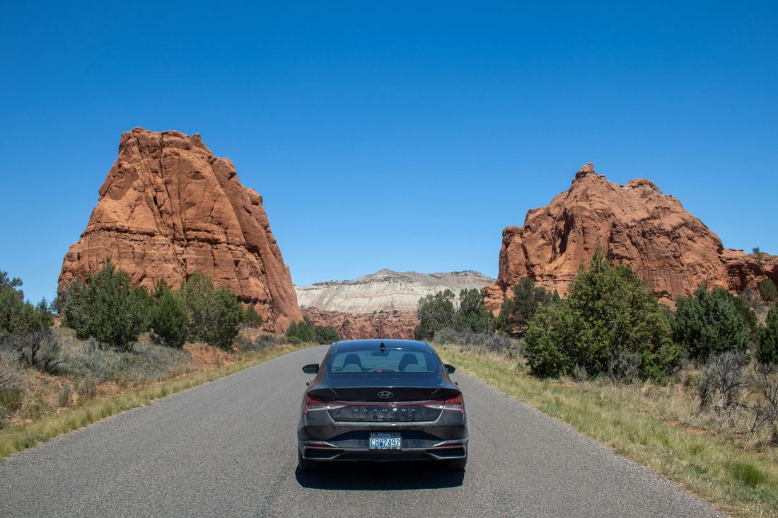 Sedan on a Southern Utah highway between red-rock formations near St. George — a driver back on the road after an SR-22 filing in Washington County.