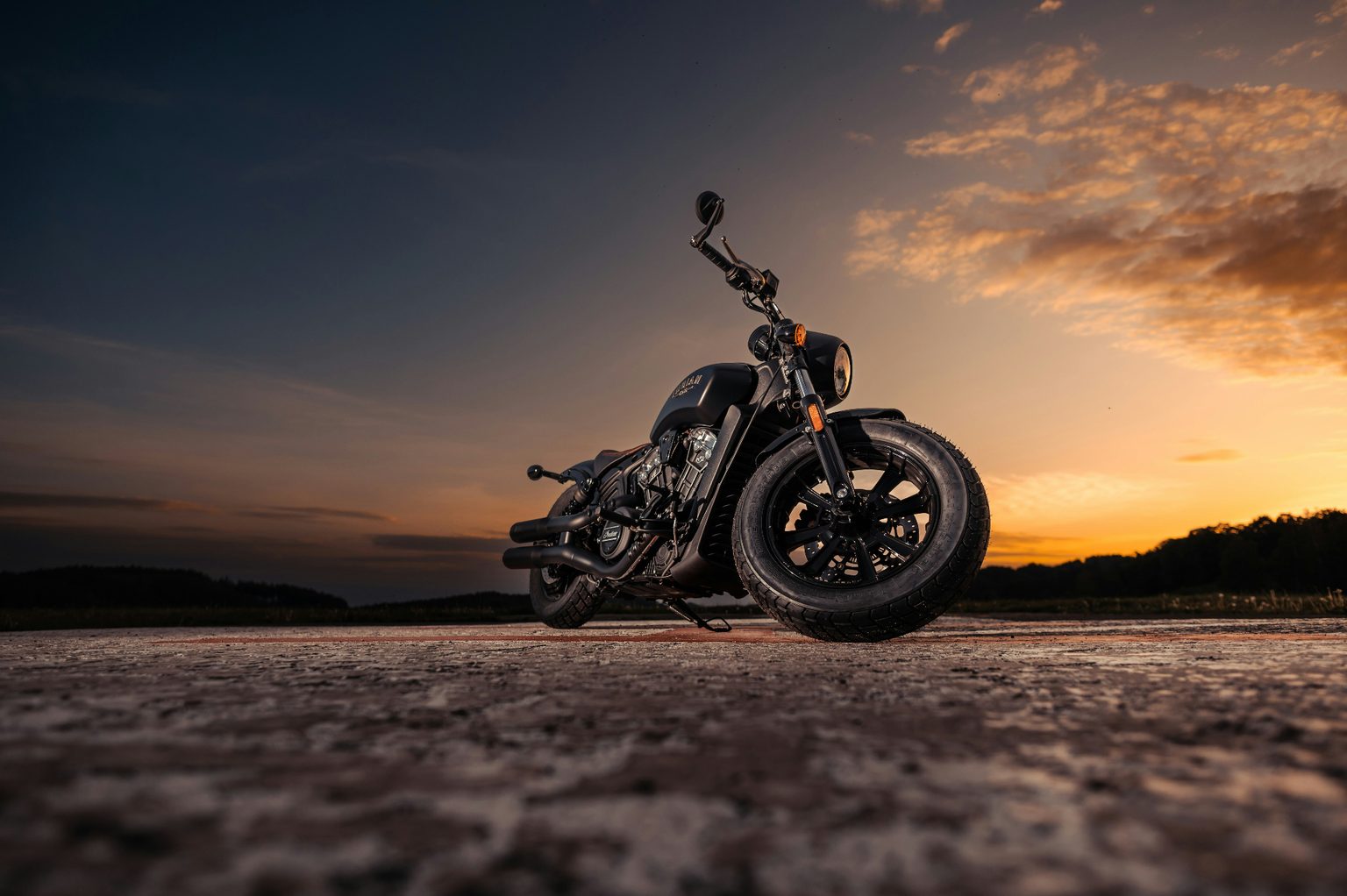 Blacked-out Indian Scout Bobber at sunset on an open Utah road