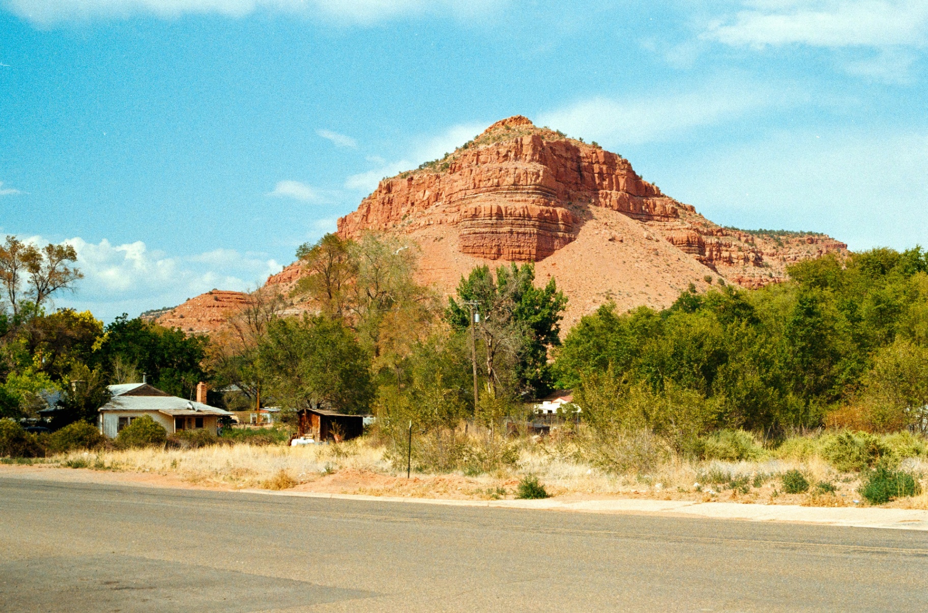 Homeowners insurance Kanab, Utah (84741) — small-town Kanab home tucked under a towering red sandstone butte at the edge of downtown, the rebuild-cost and wildland-urban interface profile that shapes 84741 home policies