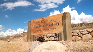 Hurricane Valley welcome sign with red-rock cliffs and blue sky — Hurricane, UT auto insurance