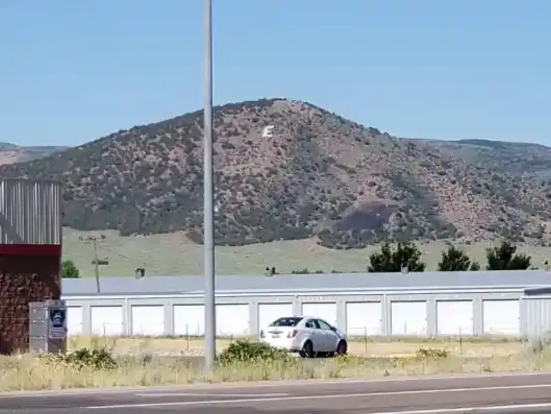 The white 'E' for Enterprise High School painted on the hillside above town in Enterprise, Utah — visible from SR-18 above the storage units on the south edge of 84725.