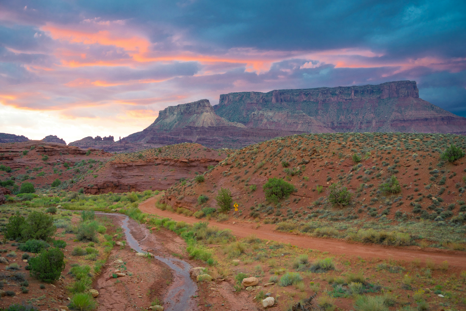 Homeowners insurance La Verkin, Utah (84745) — Smith Mesa and the Virgin River drainage at sunset with red-dirt wash cutting through sagebrush benches, the flood-corridor and wildland edge that shape 84745 home rebuild costs
