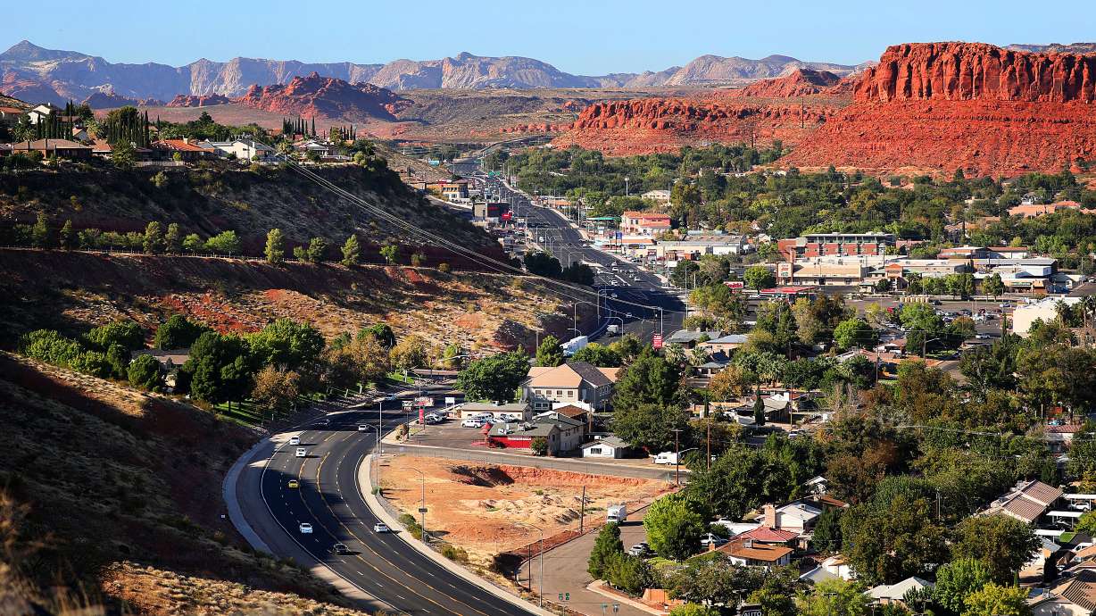 Red sandstone mesa above a St. George highway corridor — Southern Utah landscape that drives local rebuild costs.