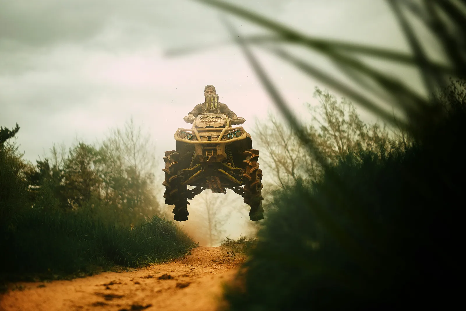 ATV catching air on a dirt trail — rollover and collision coverage on Sand Hollow rides