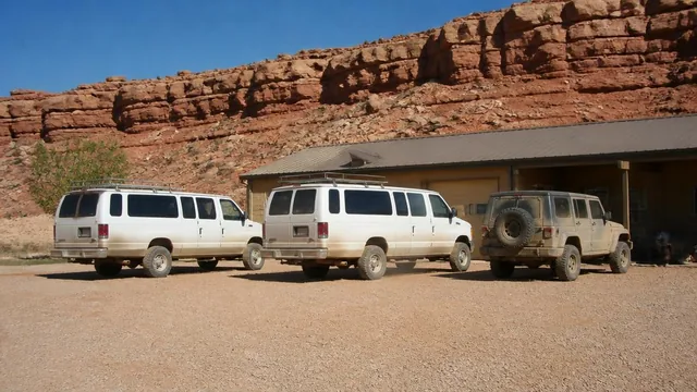 Dusty tour vehicles parked outside an outfitter's building below vermilion cliffs in Kanab, Utah — local commercial insurance risk factors for Kanab, Utah 84741 businesses