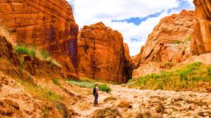 Hiker in a red sandstone slot canyon near Kanab, Utah — the kind of remote Kane County terrain that shapes auto-insurance rating