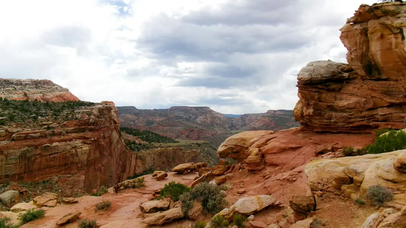 View from a red rock cliff across a wide canyon valley near Ivins, Utah — 84738 health insurance for Kayenta and Entrada households above the ACA subsidy range