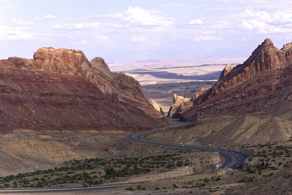 Interstate 70 motorcycle route winding through Utah's red-rock canyons at golden hour — OnPoint Utah Motorcycle Insurance.