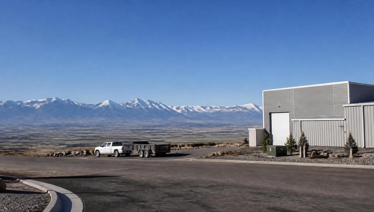 Light-industrial shop buildings on the edge of Enoch, Utah with snow-capped peaks beyond (ZIP 84721) — business insurance, BOP, general liability, commercial property and workers' comp for Enoch, Utah employers