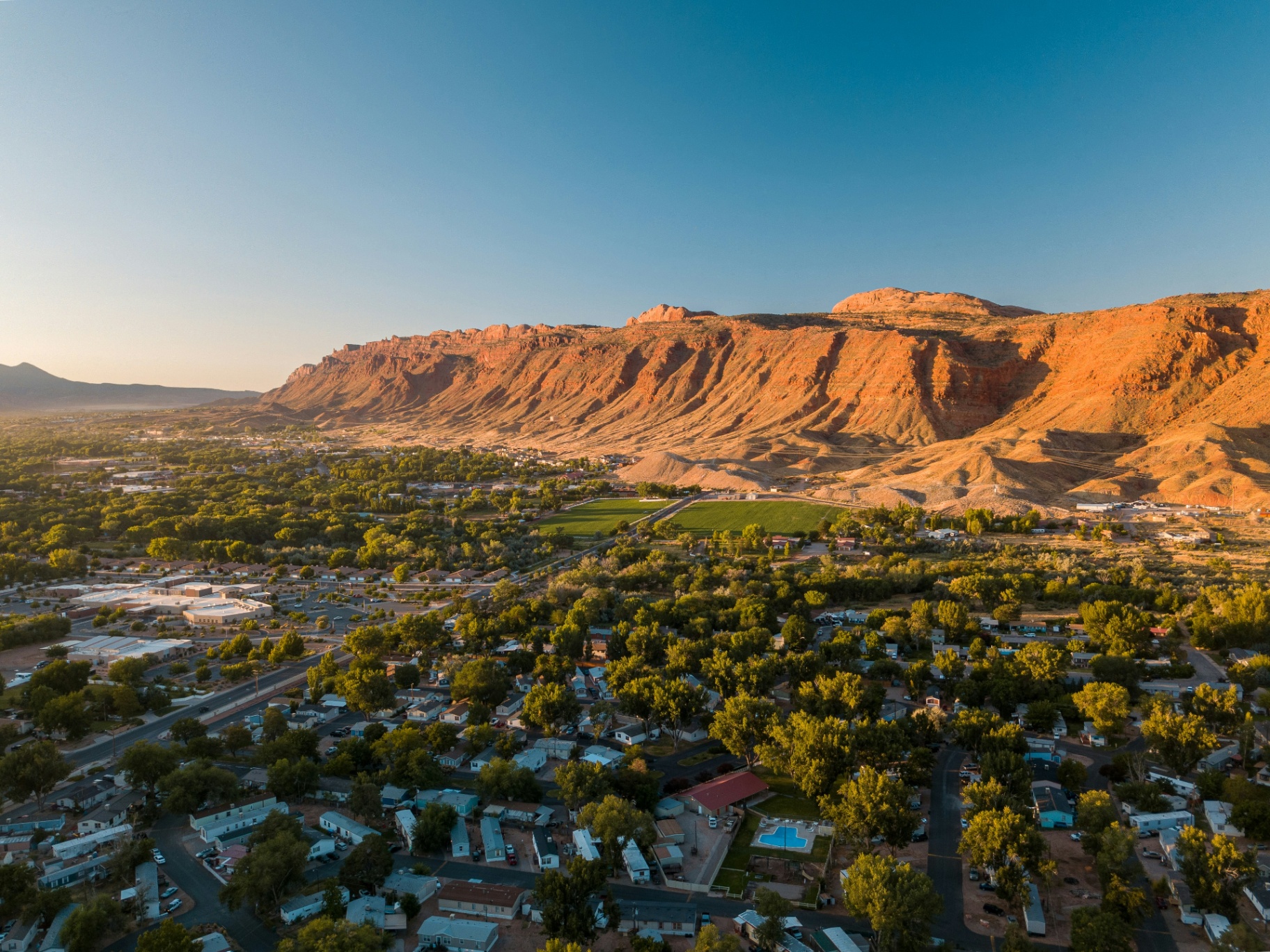 Aerial view of Hurricane, Utah with red cliffs at golden hour
