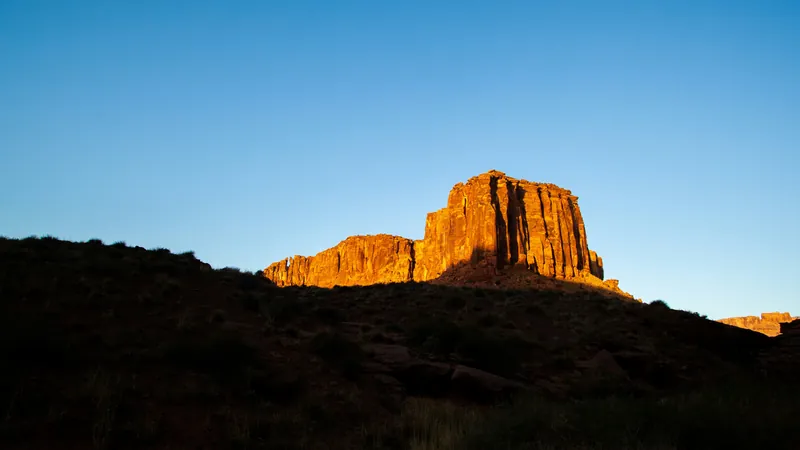 First light on a red sandstone butte above dark desert benches near Washington, Utah — 84780 ACA health insurance for Washington City families and self-employed households