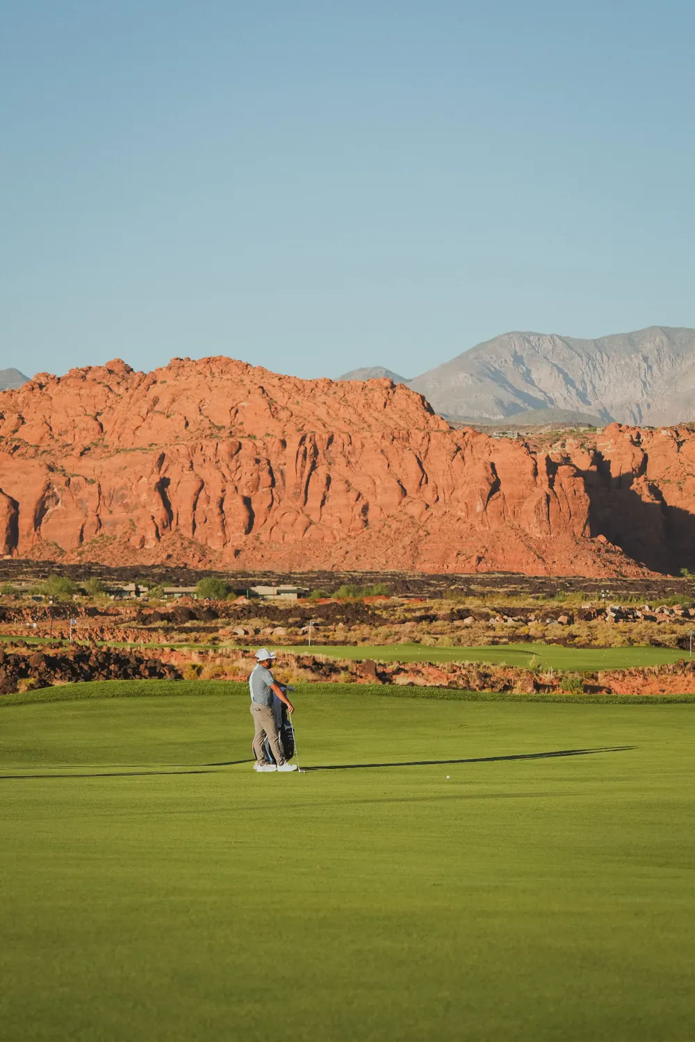 Entrada at Snow Canyon fairway framed by red sandstone cliffs and desert mountains in Ivins, Utah — the custom-home rebuild profile carriers rate into every 84738 homeowners insurance quote