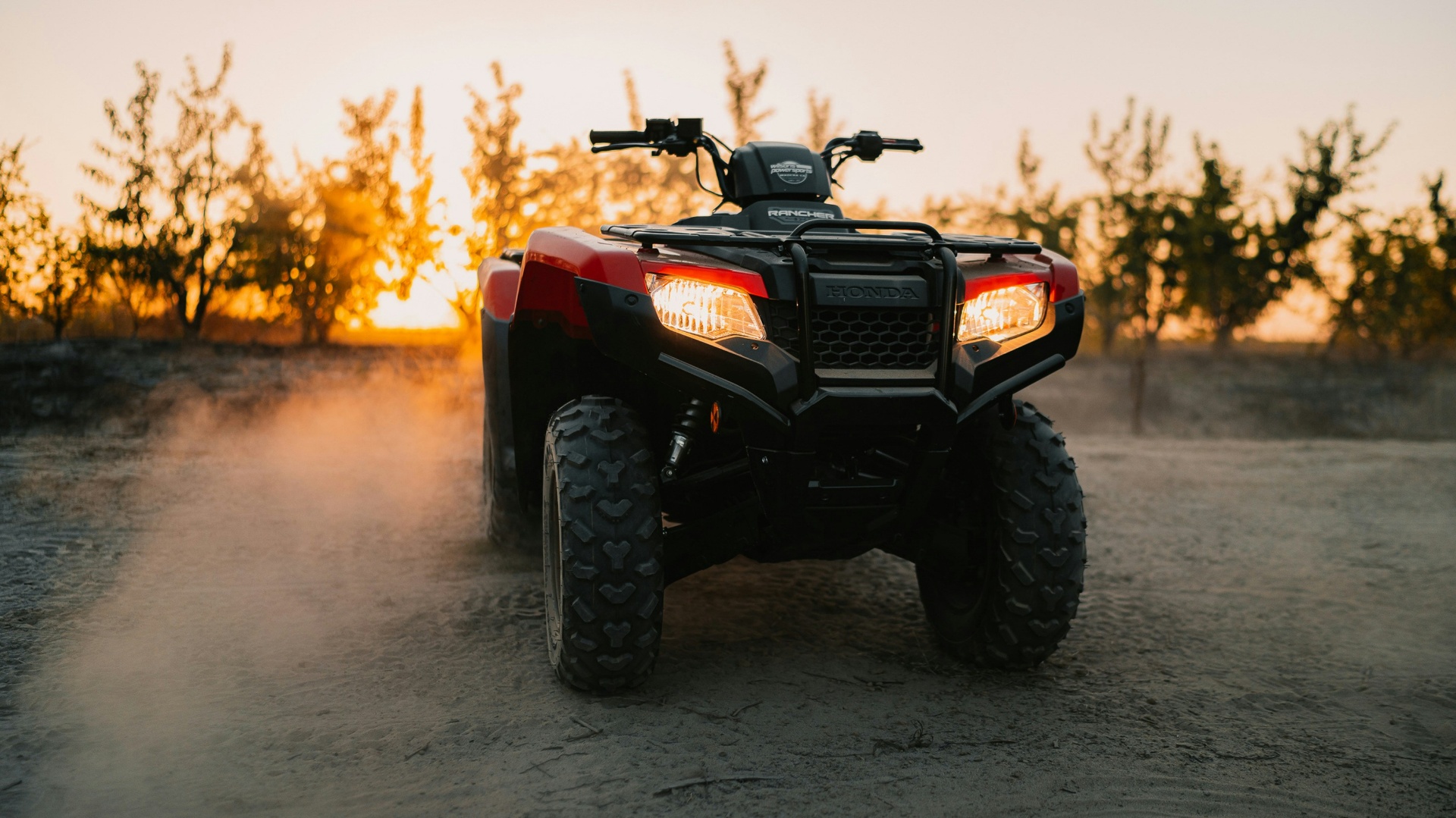 Honda Rancher ATV at sunset with headlights on — Washington City Utah ATV insurance for utility quads