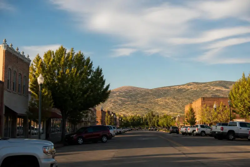 Brick storefronts and angled parking along Main Street in Richfield, Utah with the Pahvant Range beyond — free ACA health insurance enrollment for Sevier County households in 84701