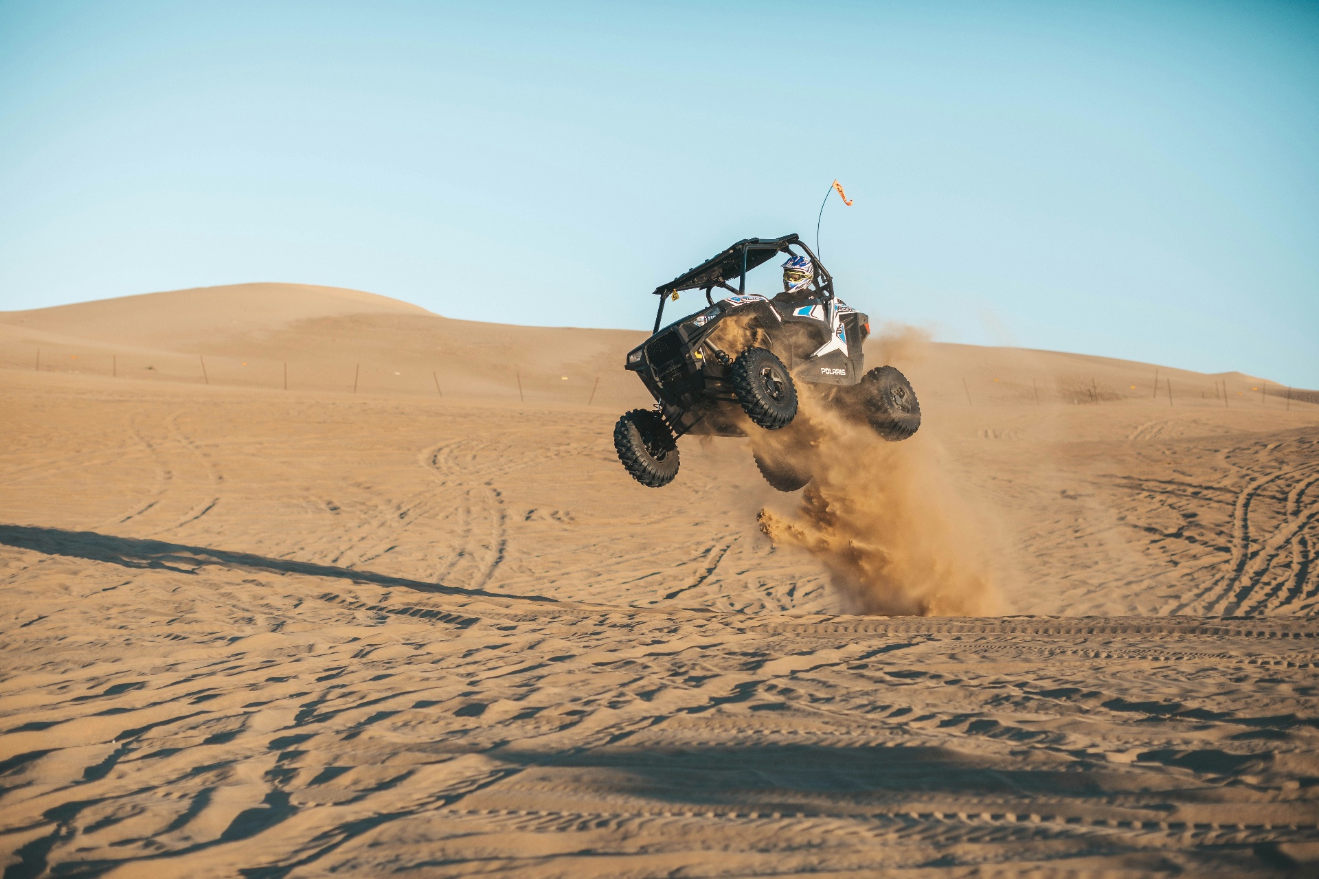 Polaris RZR side-by-side catching air in the Utah sand dunes — ATV and UTV insurance for dune riding