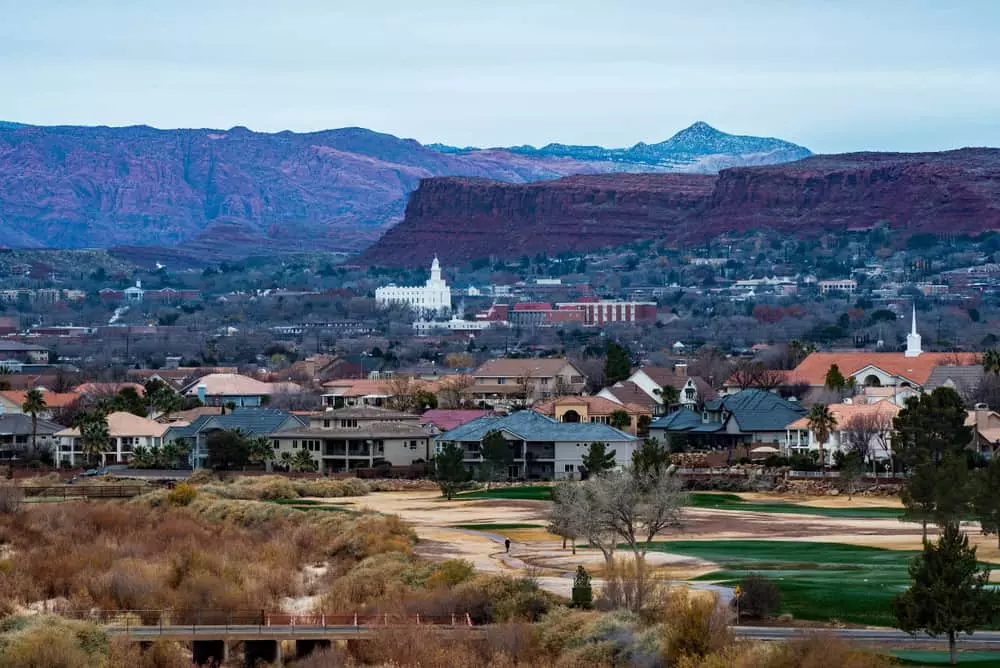View across St. George, Utah with the LDS temple, red rock cliffs, and Pine Valley Mountain — Southern Utah neighborhoods OnPoint Insurance protects.