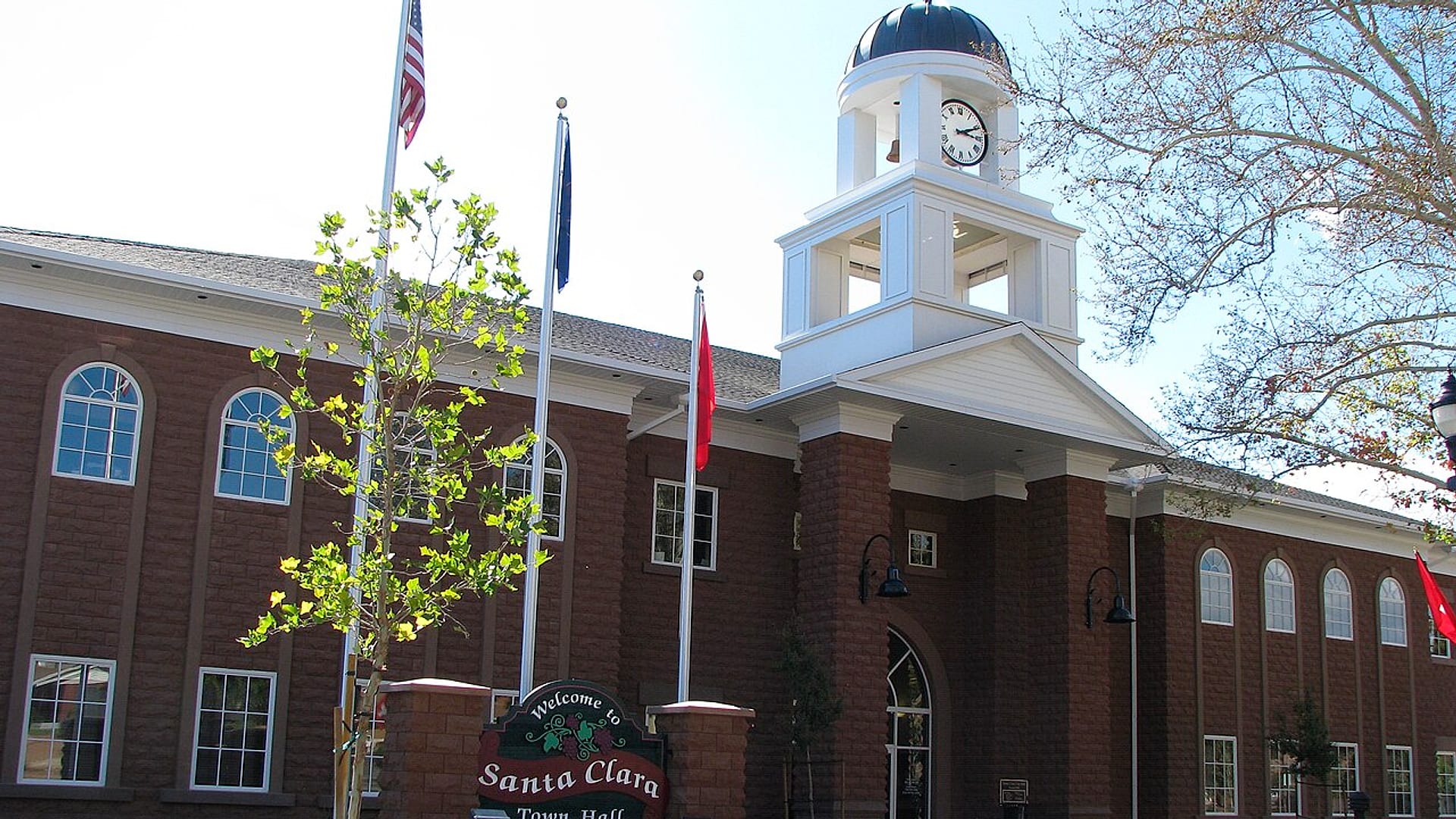 Santa Clara Town Hall in Santa Clara, Utah with clock tower, flags and welcome sign — auto insurance for Santa Clara drivers