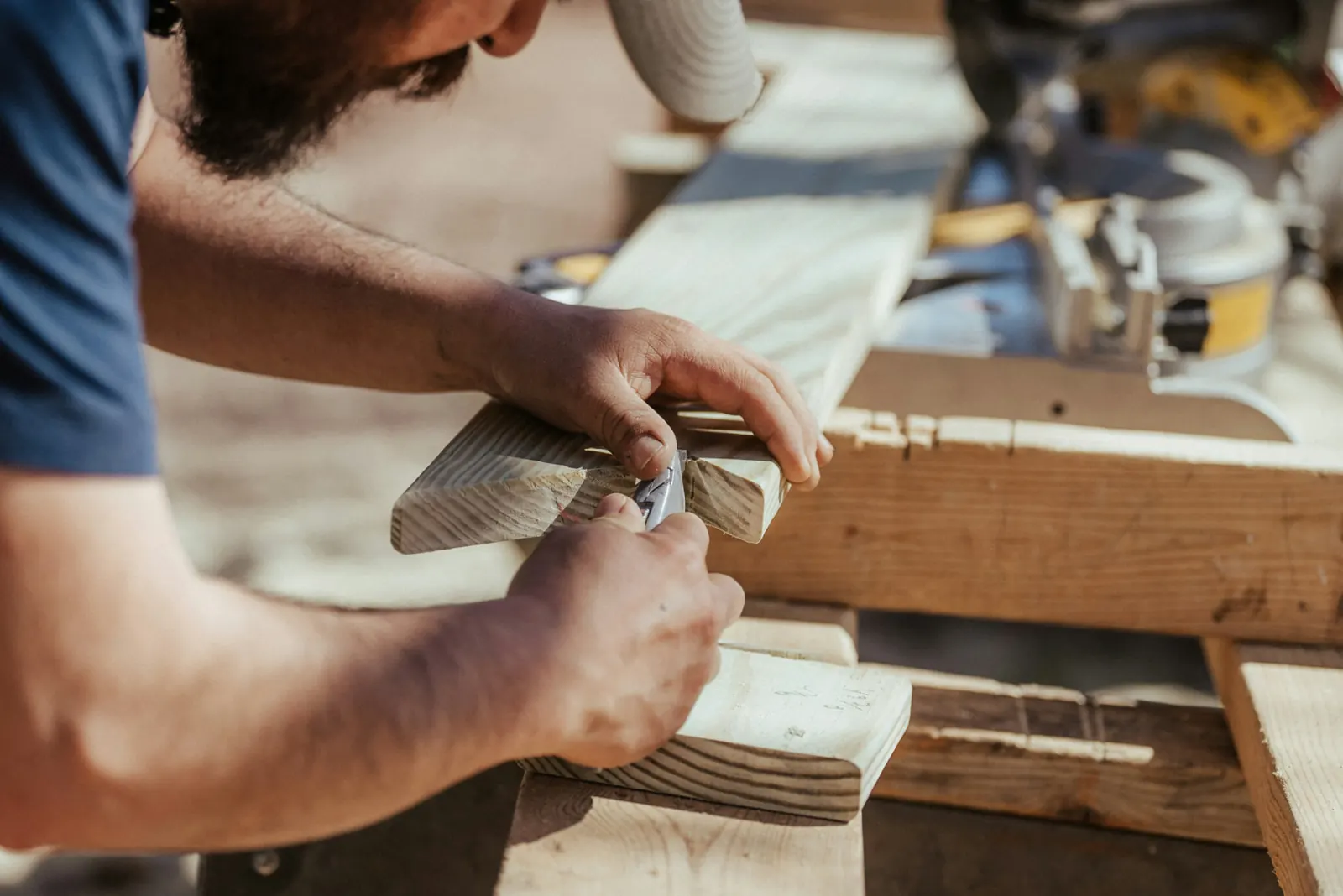 Finish carpenter marking a board with a utility knife