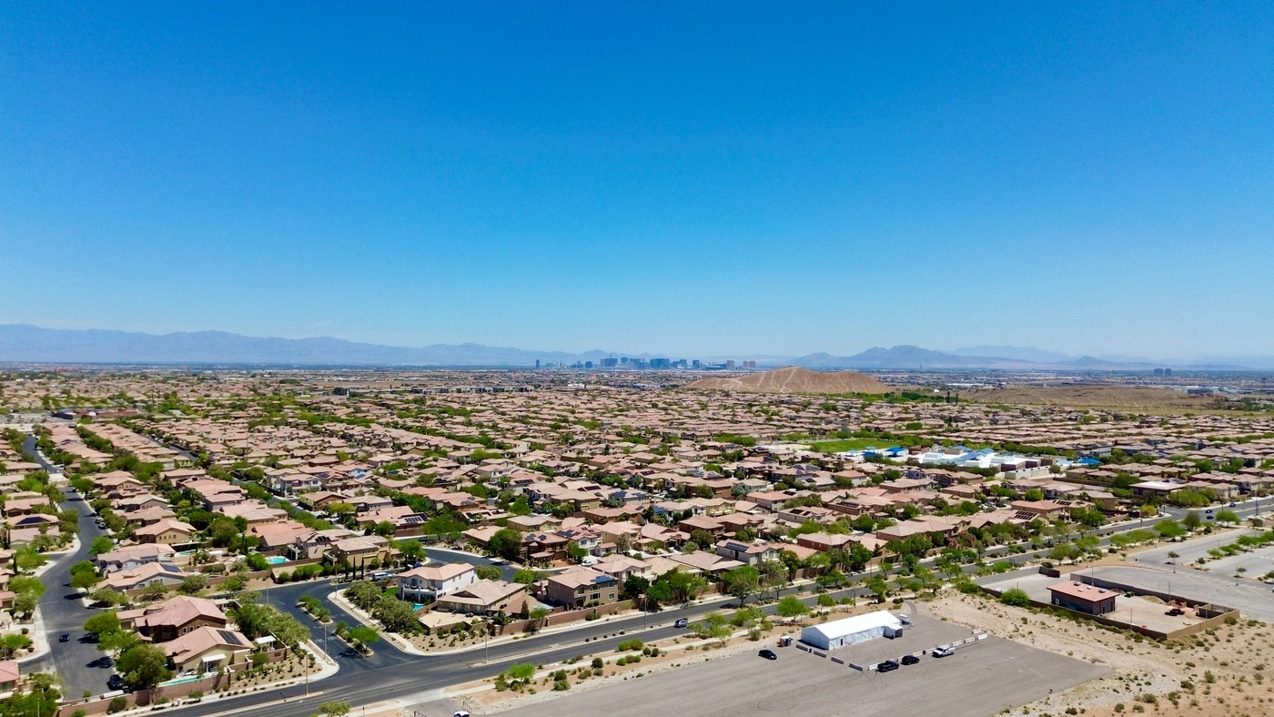 Aerial view of Mesquite, Nevada residential neighborhoods stretching toward the Las Vegas Strip skyline on the I-15 corridor — Clark County 89027 auto insurance market