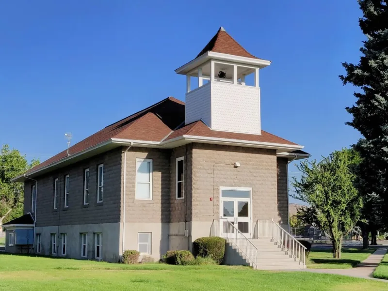Enterprise Heritage Hall — restored 1900s schoolhouse with white bell tower on the town square in Enterprise, Utah — local landmark in 84725 where OnPoint Insurance Group writes auto, home, and farm-and-ranch coverage.
