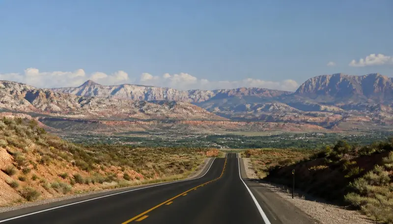 State Route 17 dropping into the Toquerville valley with red mesas beyond — health insurance and ACA Marketplace enrollment for Toquerville, Utah 84774 households