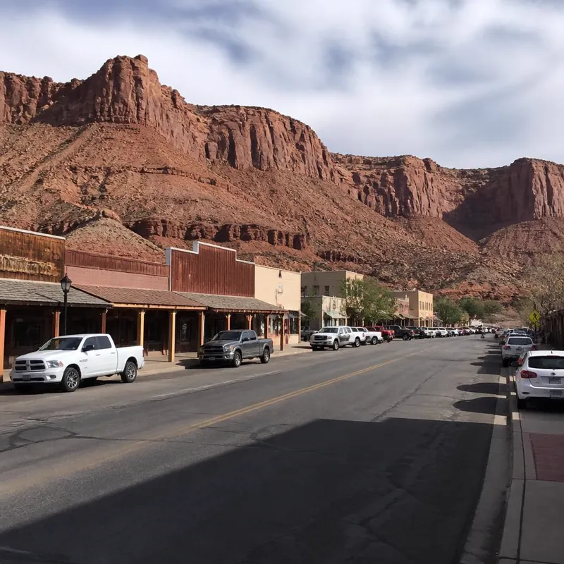 Main Street in downtown Kanab, Utah — the Kane County seat — with the red Vermilion Cliffs rising behind the western storefronts