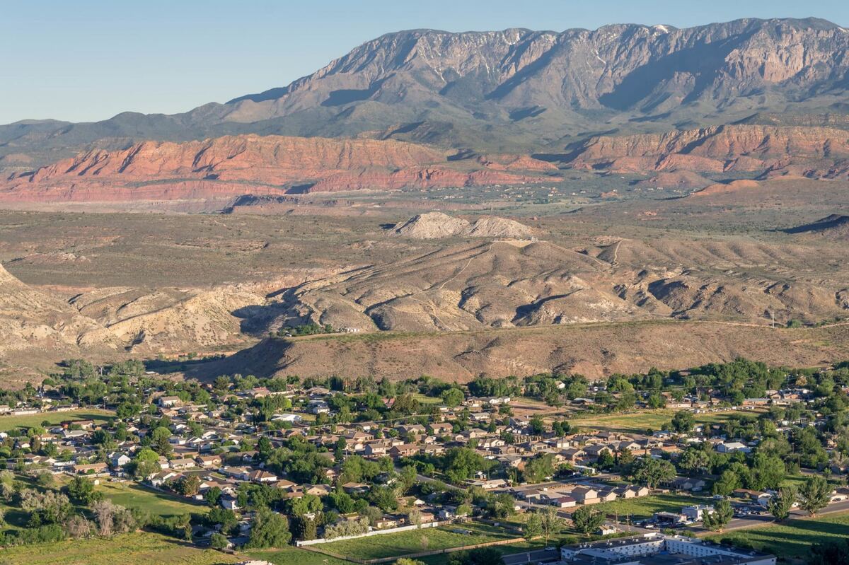 La Verkin, Utah neighborhoods at golden hour with the Red Cliffs Desert Reserve and Pine Valley Mountain rising in the background — the 84745 landscape that shapes local auto insurance exposure