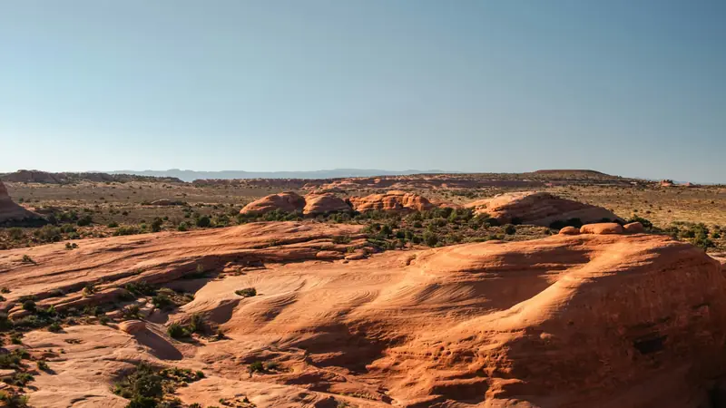 Junipers scattered across red slickrock benches near Hurricane, Utah — the 84737 country served by OnPoint's ACA Marketplace enrollment