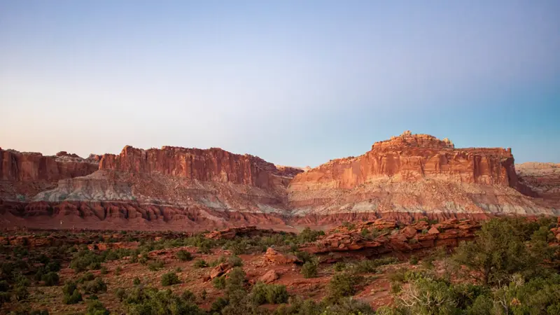 Layered red sandstone cliffs at dusk above juniper flats near La Verkin, Utah — ACA Marketplace and Utah Medicaid eligibility for 84745 households