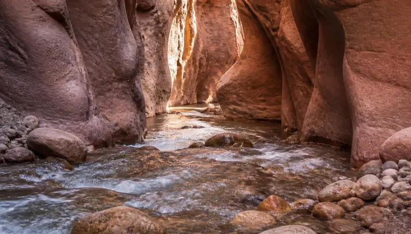 Narrow slot canyon creek with orange sandstone walls near Kanarraville, Utah — health insurance and ACA Marketplace enrollment for Kanarraville, Utah 84742 households