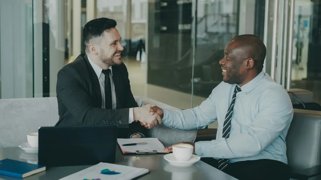 Local insurance agent shaking hands with a small business client after binding cyber coverage
