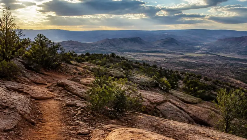 Red dirt slickrock trail on the benches above Virgin, Utah at sunset — health insurance and ACA Marketplace enrollment for Virgin, Utah 84779 households