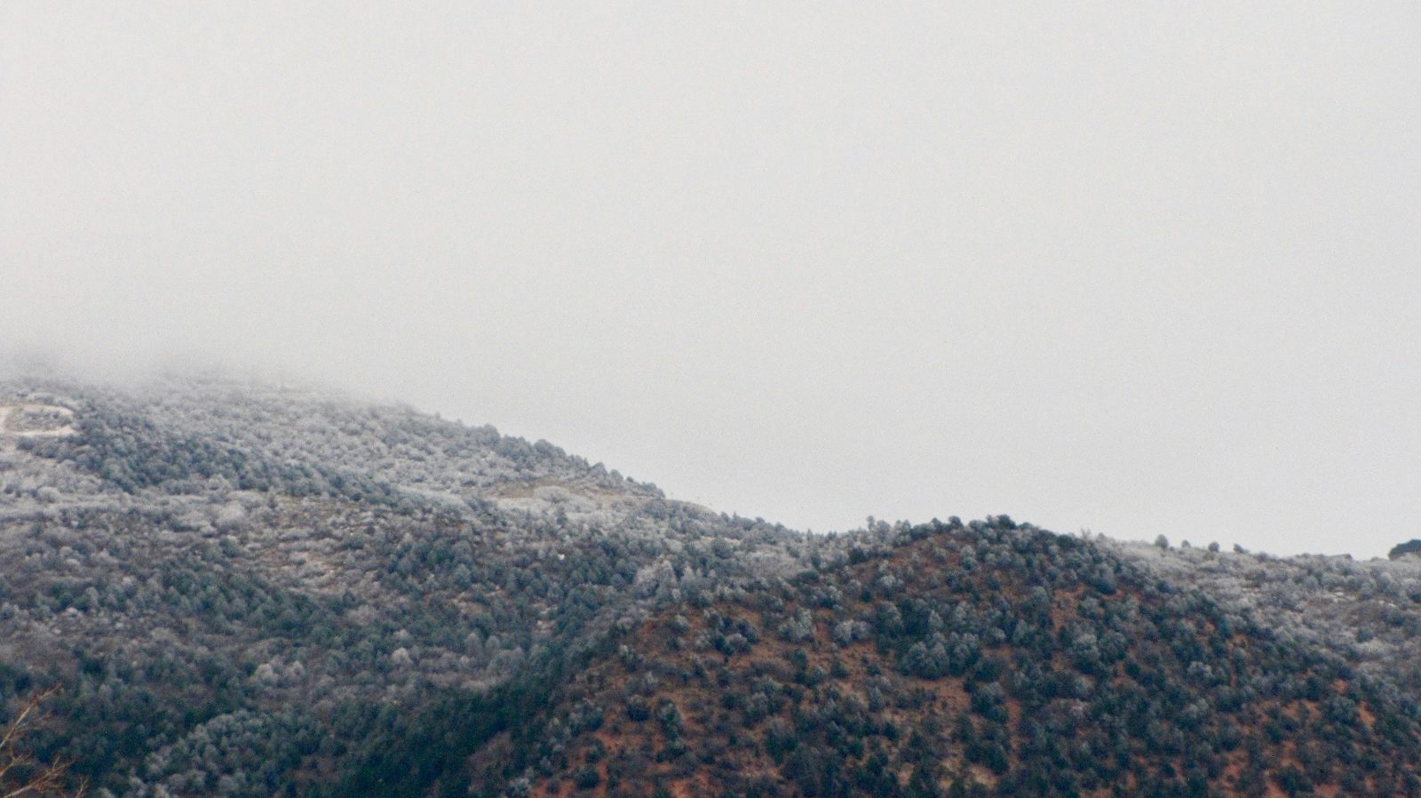 Foggy snow-dusted mountainside above Cedar City, Utah