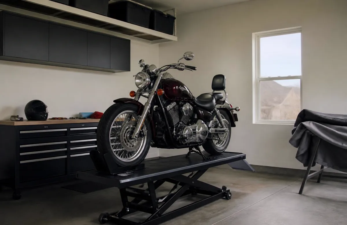 Cruiser on a lift inside a clean home garage in Parowan, with a winter storage cover nearby — motorcycle insurance for Parowan, Utah riders