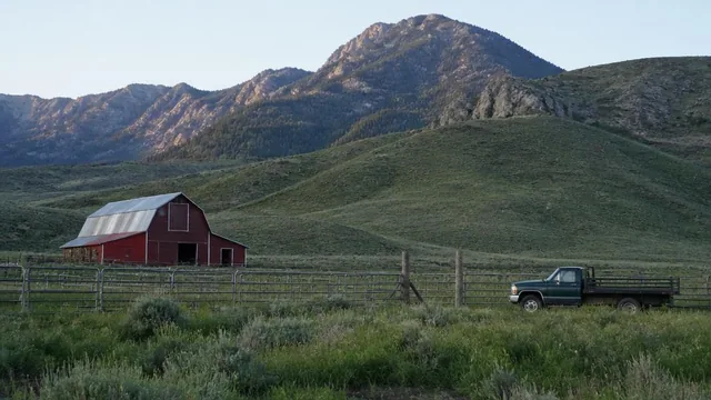 Barn, corrals and a farm truck on the green valley floor in New Harmony, Utah — local commercial insurance risk factors for New Harmony, Utah 84757 businesses