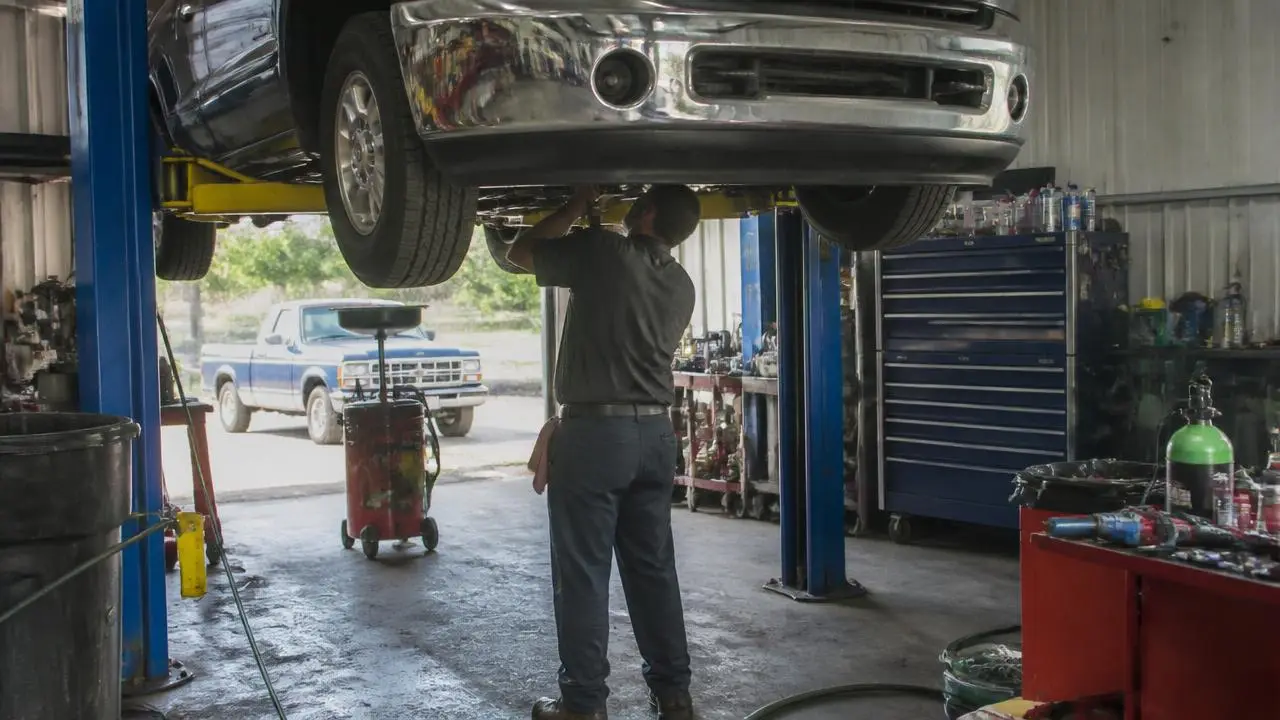 Mechanic working under a truck on a lift in a Parowan, Utah garage — business insurance, BOP, general liability and workers' comp for Parowan, Utah 84761 employers