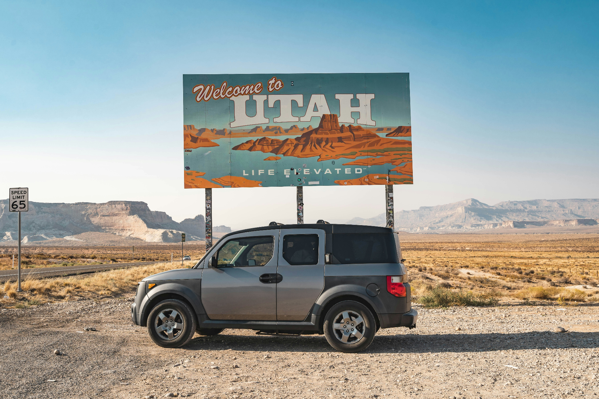 Welcome to Utah highway sign with red rock mesas near the Arizona–Utah border — Washington County, UT