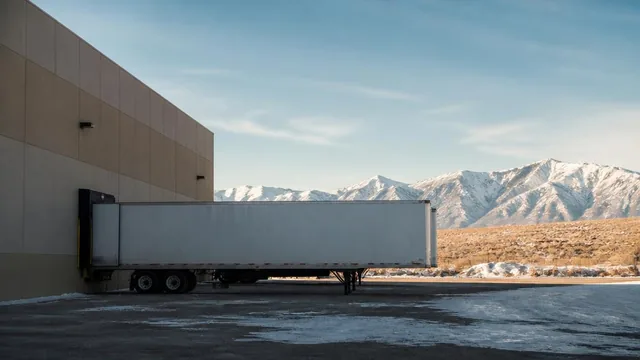 Warehouse loading dock and semi trailer with snowy peaks behind in Enoch, Utah — local commercial insurance risk factors for Enoch, Utah 84721 businesses