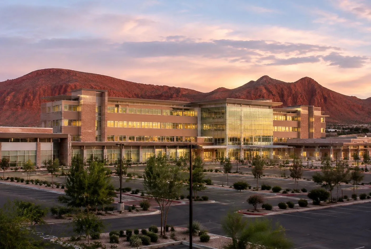 Regional hospital campus at dusk with red sandstone hills behind it in Southern Utah