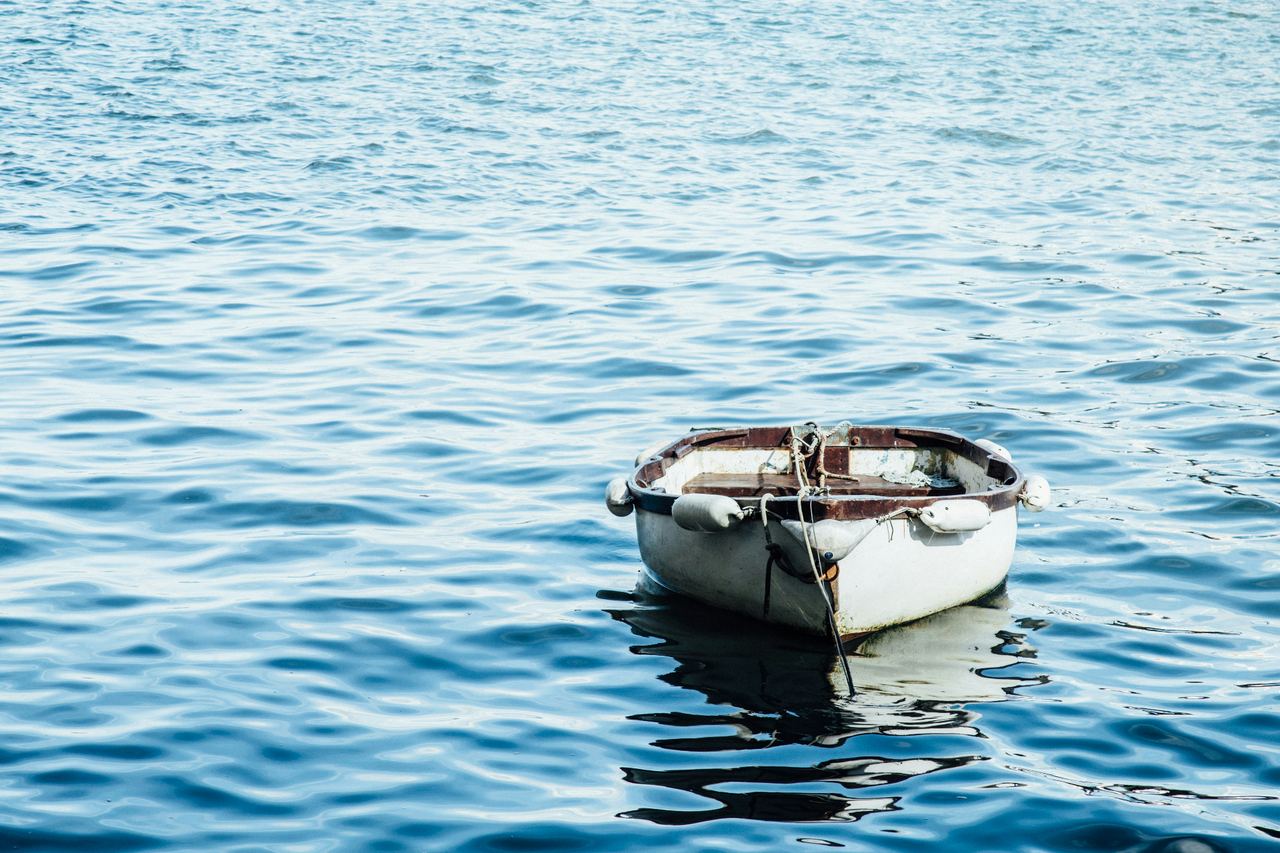 Small white boat floating on calm blue water — boat insurance in St. George, Utah