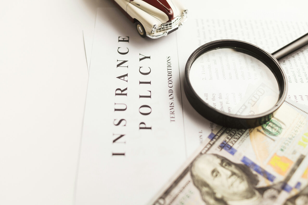 Insurance policy documents with magnifying glass — business insurance coverage in St. George, Utah
