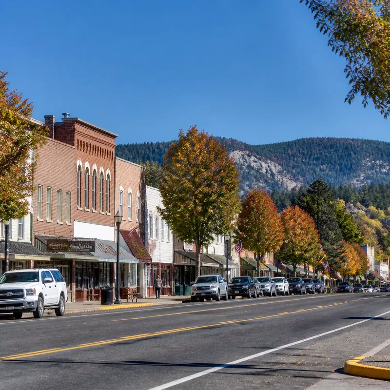 Historic red-brick storefronts on Main Street in Panguitch, Utah, with the forested plateau above the Garfield County seat