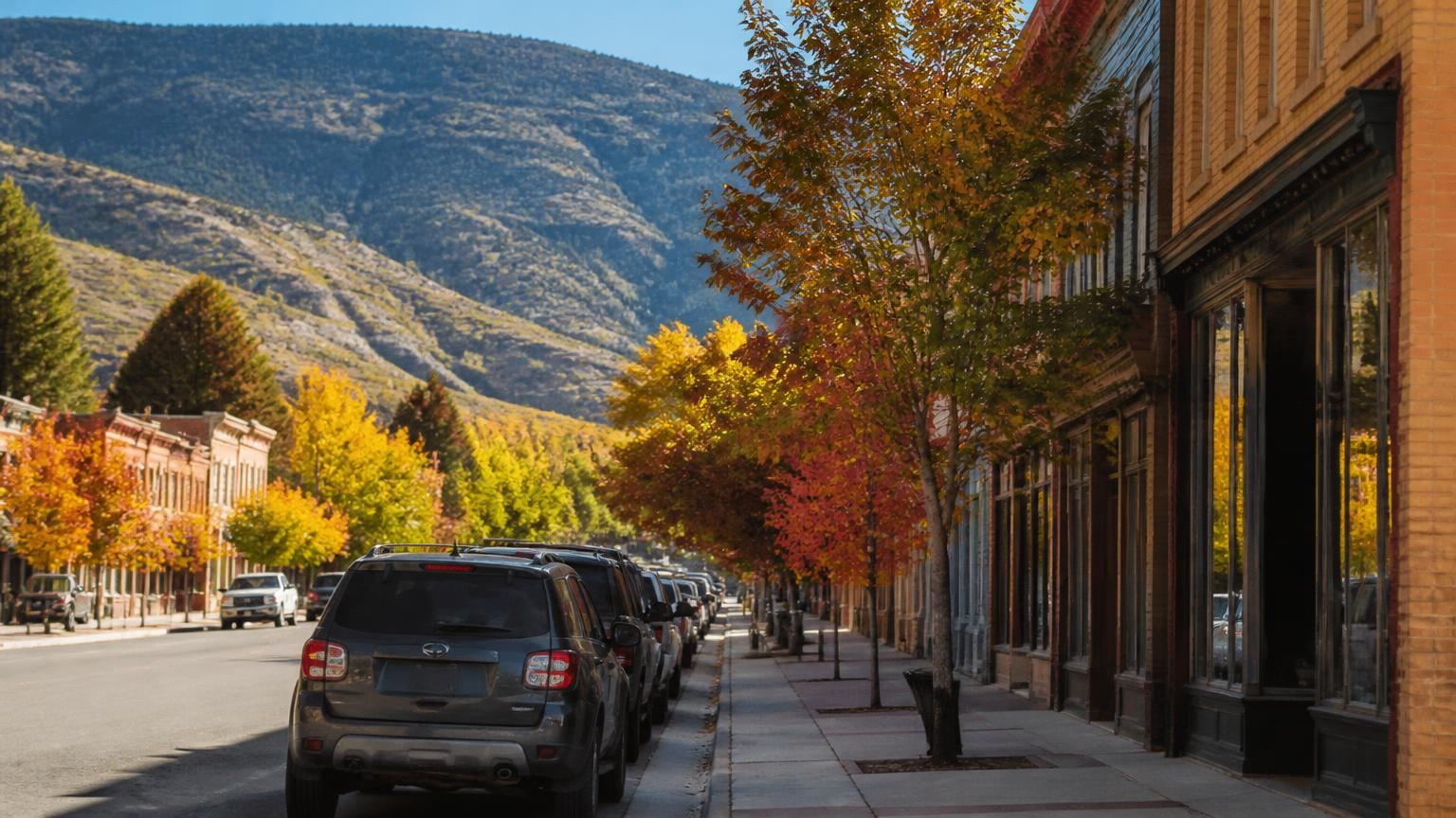Car insurance in Parowan, Utah (84761) — historic Main Street with pioneer red-brick storefronts, shade trees and parked cars