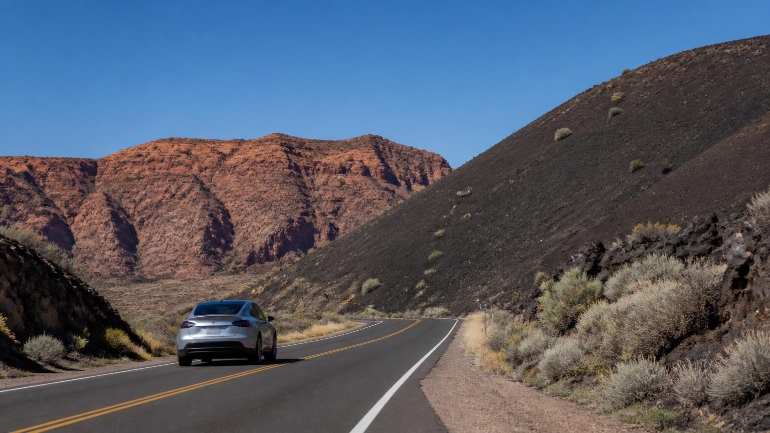 Car insurance in Veyo, Utah (84782) — the Veyo volcano cinder cone and red cliffs along State Route 18 with a pickup truck on the two-lane highway